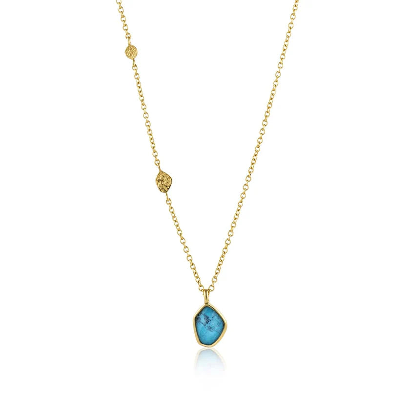Gold necklace with a blue pendant on a white background